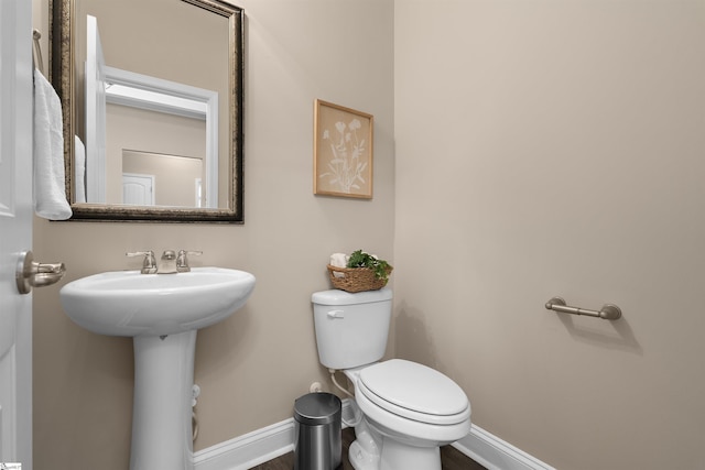 bathroom with a sink, baseboards, and toilet