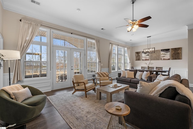 living room with visible vents, dark wood-style flooring, ceiling fan, french doors, and crown molding