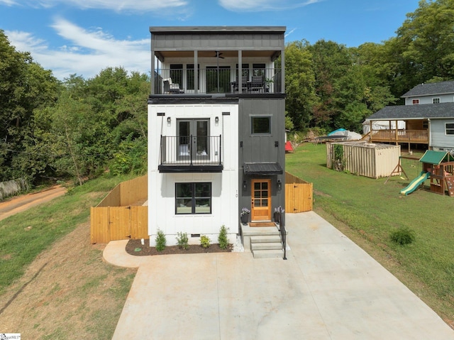 view of front of home featuring board and batten siding, a balcony, crawl space, a gate, and a playground