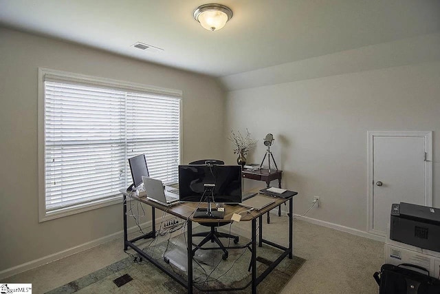 carpeted office with lofted ceiling, baseboards, and visible vents