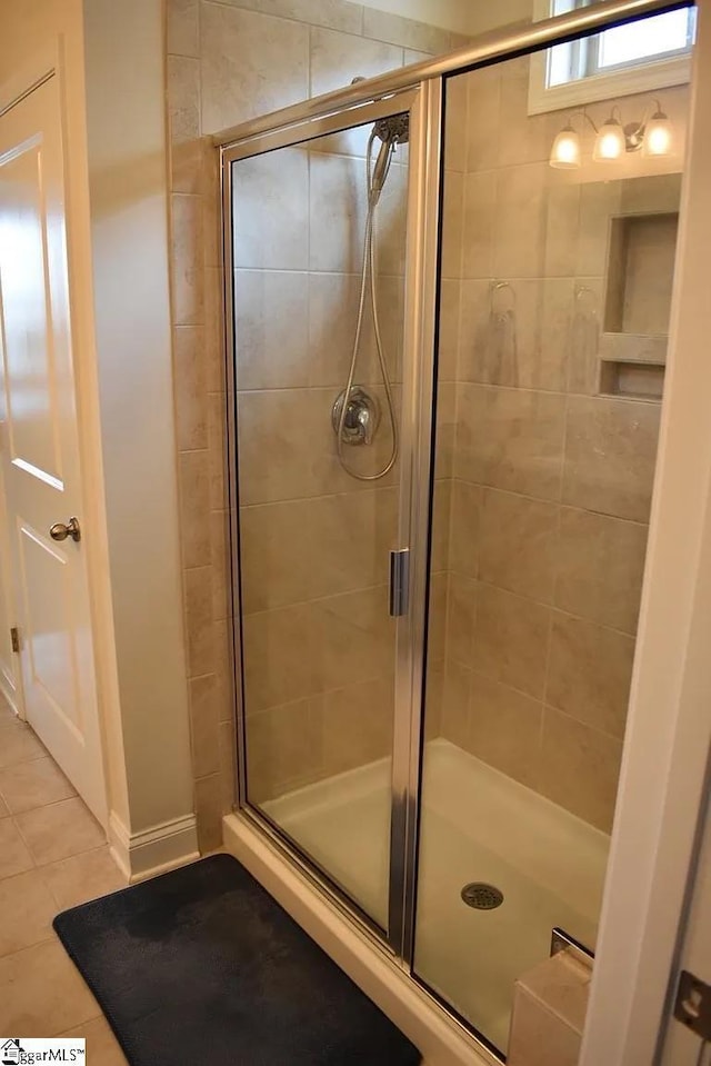 full bathroom with tile patterned floors, a stall shower, and baseboards