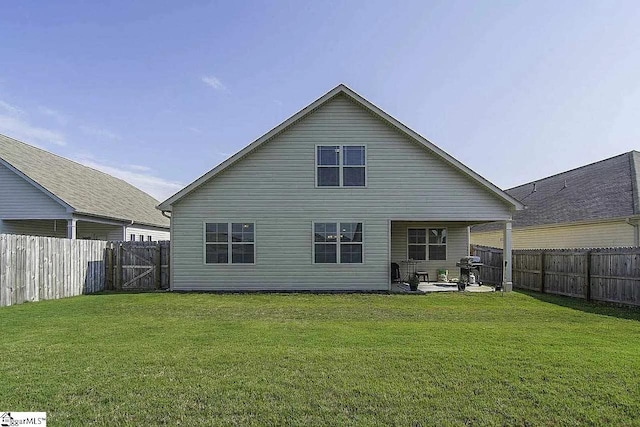 rear view of property with a yard, a patio, and a fenced backyard