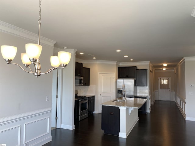 kitchen featuring dark wood-type flooring, light stone counters, a sink, stainless steel appliances, and hanging light fixtures