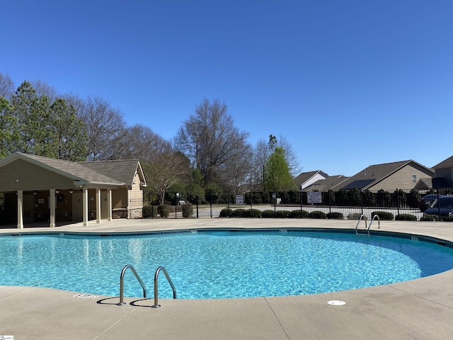 pool with a patio and fence