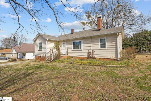 view of front of property with a chimney and a front lawn