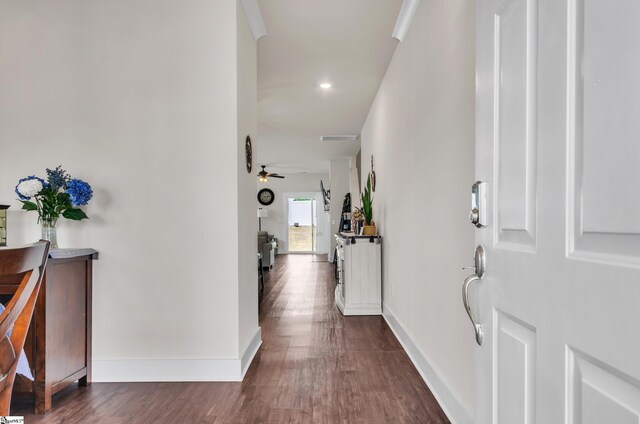 foyer featuring ceiling fan, visible vents, baseboards, and dark wood-type flooring