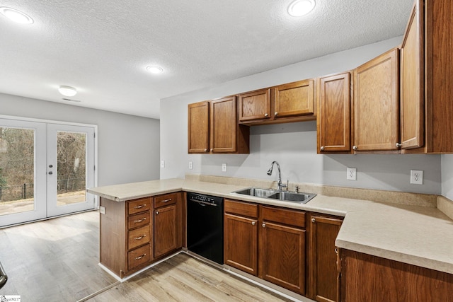 kitchen featuring a peninsula, a sink, black dishwasher, light countertops, and french doors