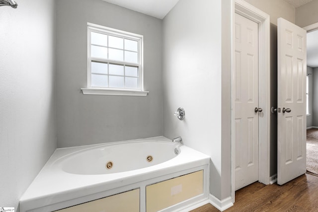 bathroom featuring a jetted tub and wood finished floors