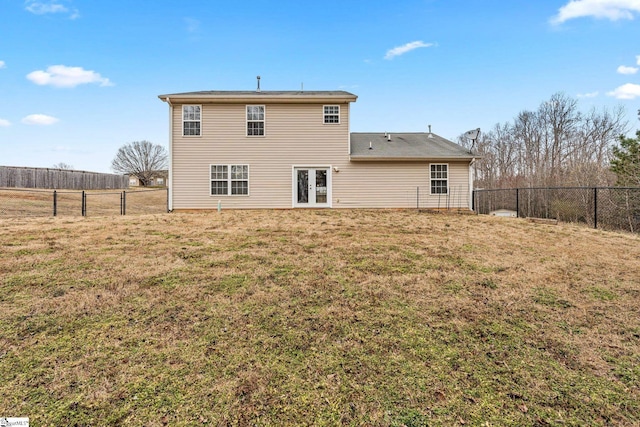 rear view of house featuring a yard, french doors, and a fenced backyard