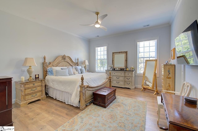 bedroom featuring ceiling fan, visible vents, baseboards, light wood-style floors, and ornamental molding