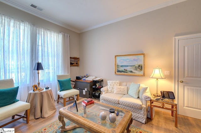 living area with ornamental molding, visible vents, and light wood-style floors