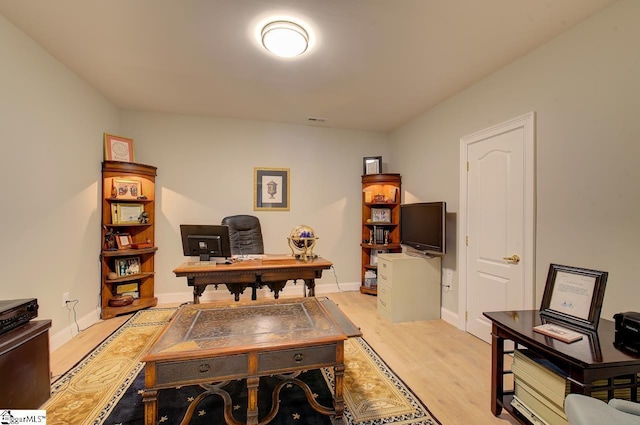 office with light wood-type flooring, visible vents, and baseboards