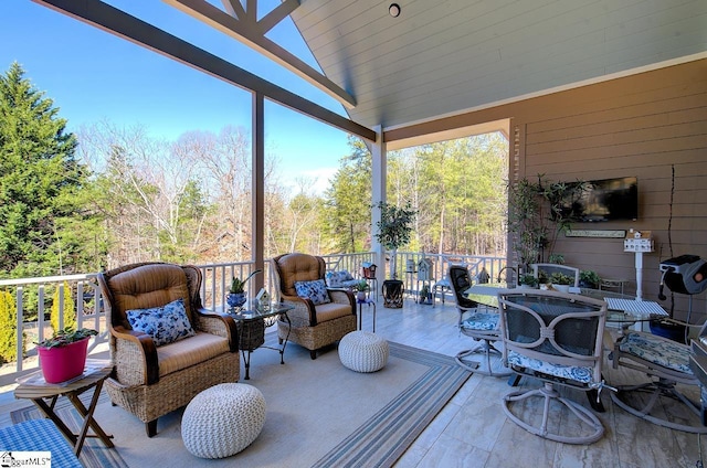 wooden terrace with outdoor dining area and an outdoor living space