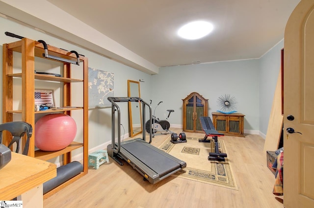 workout area featuring baseboards and wood finished floors