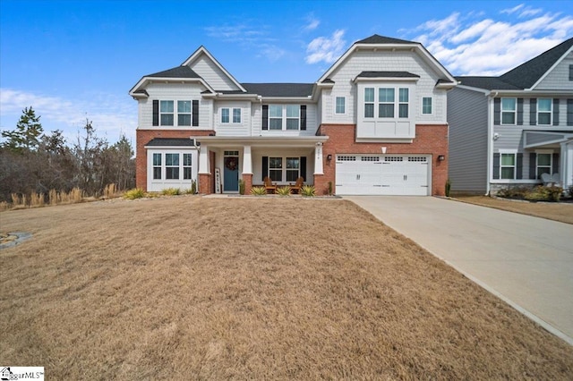 craftsman inspired home with a garage, brick siding, driveway, and a front lawn