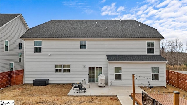 rear view of house with a patio area, a fenced backyard, and roof with shingles