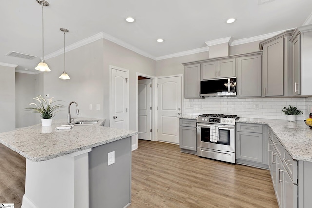 kitchen with visible vents, appliances with stainless steel finishes, gray cabinetry, light wood-type flooring, and a sink