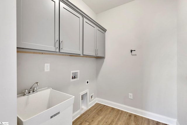 laundry area featuring cabinet space, a sink, light wood-type flooring, washer hookup, and electric dryer hookup