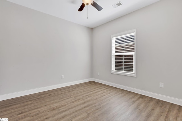 unfurnished room with a ceiling fan, baseboards, visible vents, and wood finished floors