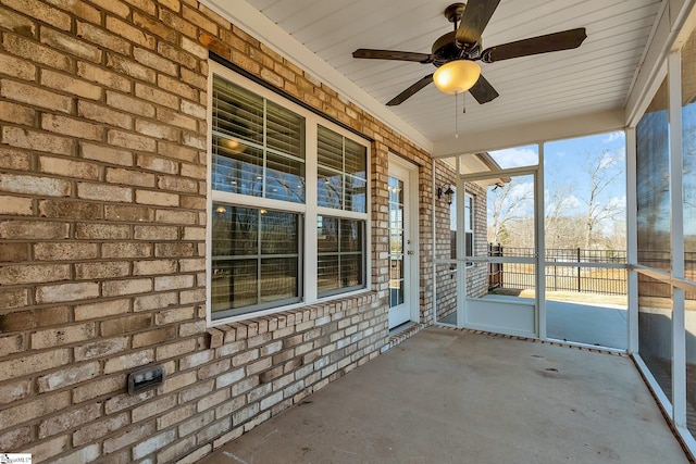 unfurnished sunroom with ceiling fan