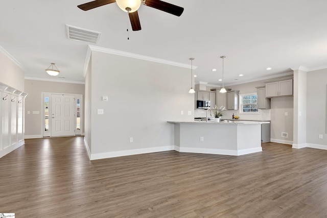 kitchen with visible vents, decorative backsplash, stainless steel microwave, a peninsula, and gray cabinets