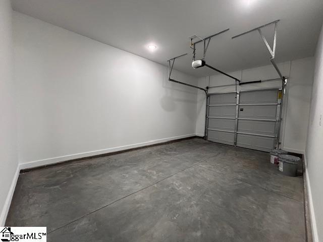 garage with baseboards and a garage door opener