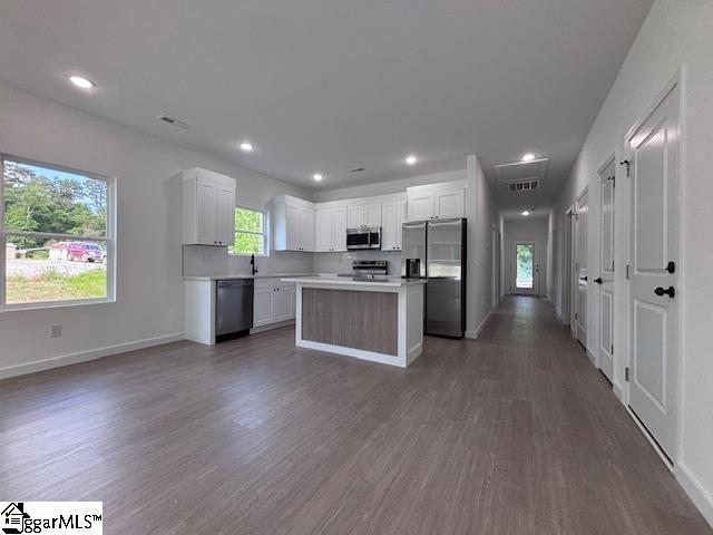 kitchen featuring light countertops, white cabinets, stainless steel appliances, and dark wood-type flooring