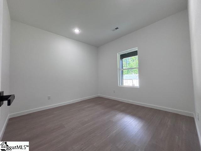 spare room with visible vents, recessed lighting, baseboards, and wood finished floors