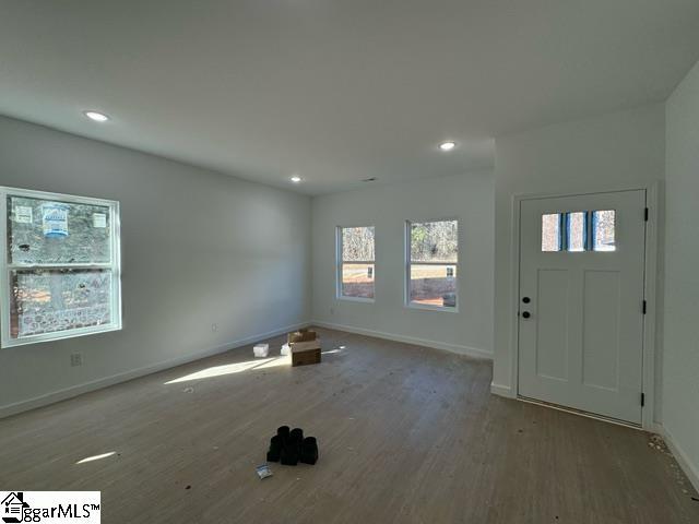 entryway with baseboards, wood finished floors, and recessed lighting