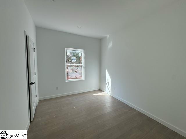 empty room with baseboards and wood finished floors