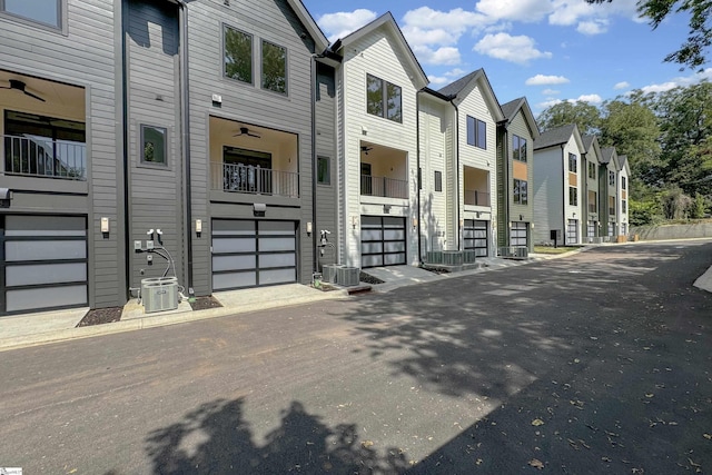 view of front facade featuring central AC unit, an attached garage, and a residential view