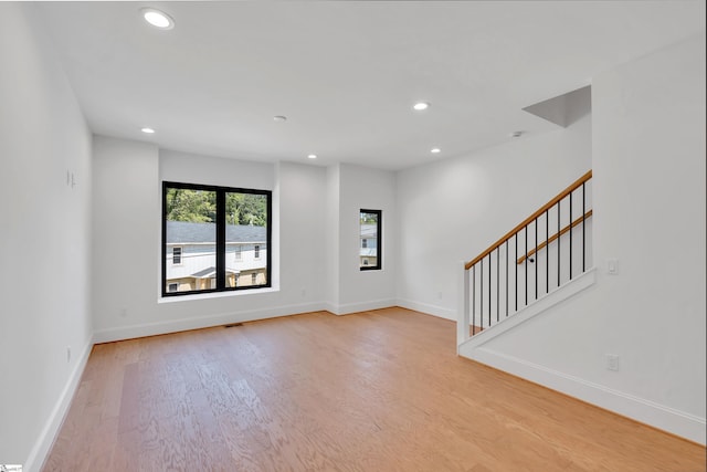 unfurnished room with light wood-style floors, stairs, baseboards, and recessed lighting