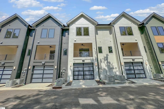 multi unit property featuring a ceiling fan, driveway, an attached garage, and central air condition unit