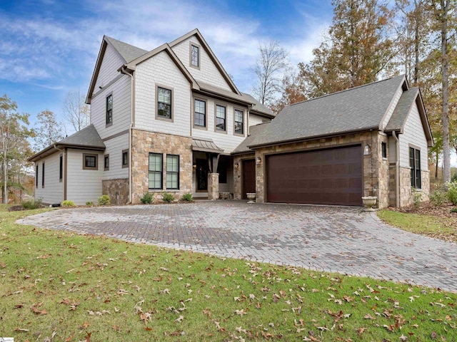 view of front of house with stone siding, a front lawn, decorative driveway, and an attached garage