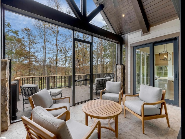 sunroom with lofted ceiling with beams, plenty of natural light, and wooden ceiling