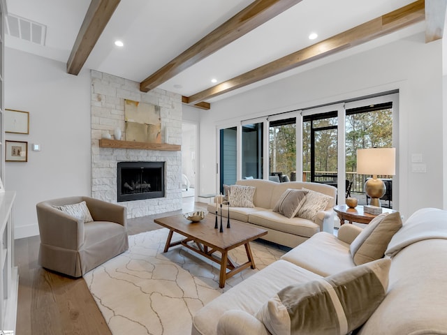 living area featuring recessed lighting, a fireplace, wood finished floors, visible vents, and beamed ceiling