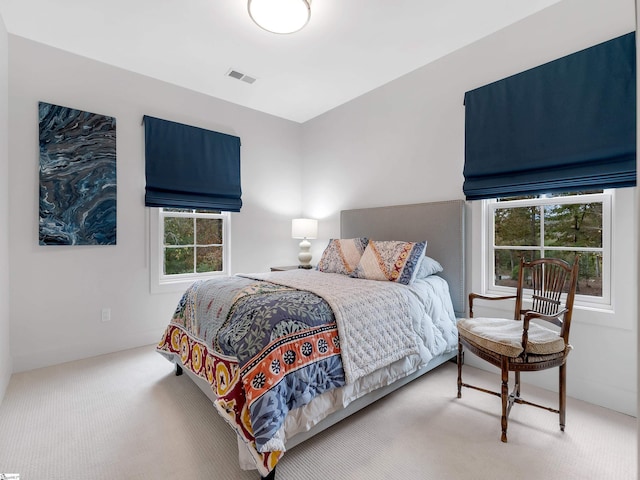 carpeted bedroom featuring visible vents