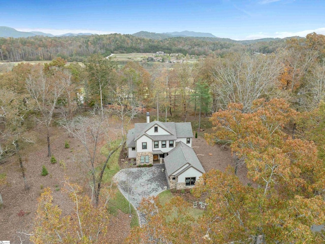 birds eye view of property featuring a mountain view and a view of trees