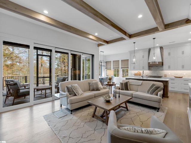 living area with light wood-type flooring, beamed ceiling, and recessed lighting