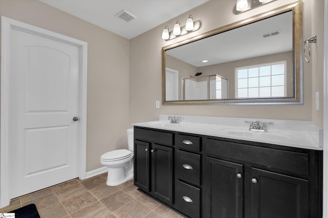 bathroom with visible vents, a sink, toilet, and double vanity