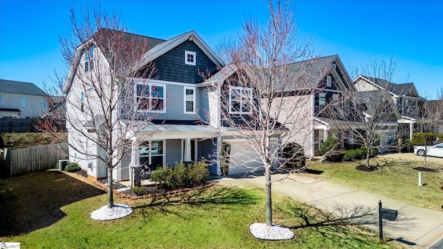 view of front facade featuring a garage, concrete driveway, fence, and a front lawn