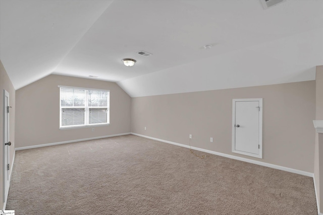 additional living space featuring carpet flooring, vaulted ceiling, visible vents, and baseboards