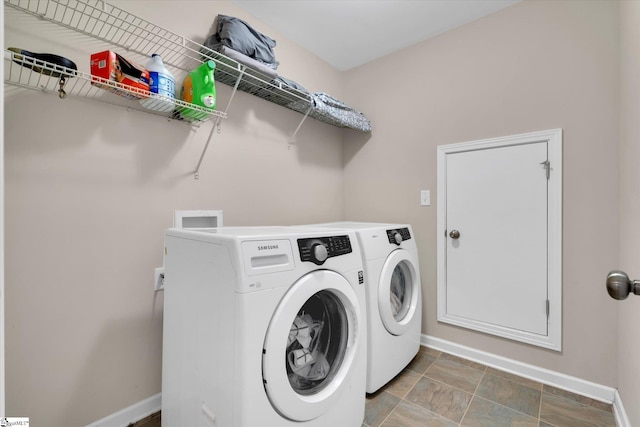 clothes washing area with laundry area, washing machine and dryer, and baseboards