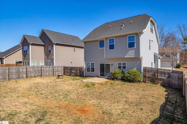 back of house featuring a fenced backyard and a yard