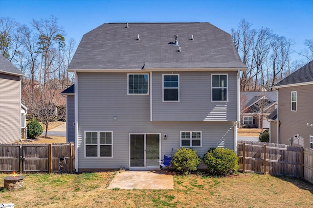 back of house with fence, a fire pit, and a yard