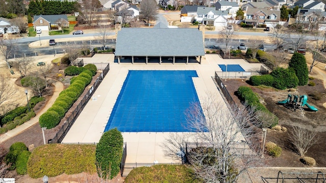 view of swimming pool featuring a residential view and fence