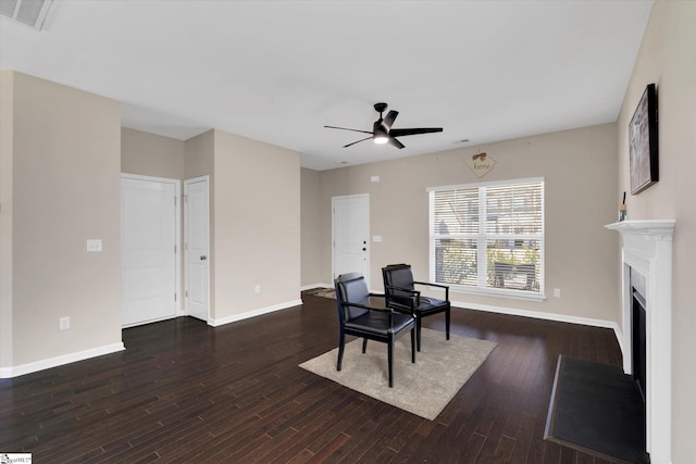 sitting room with baseboards, a fireplace, visible vents, and wood finished floors