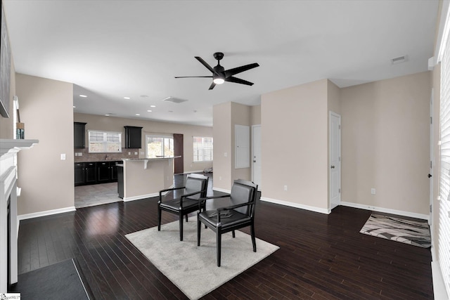 dining room with wood-type flooring, a fireplace, visible vents, and baseboards