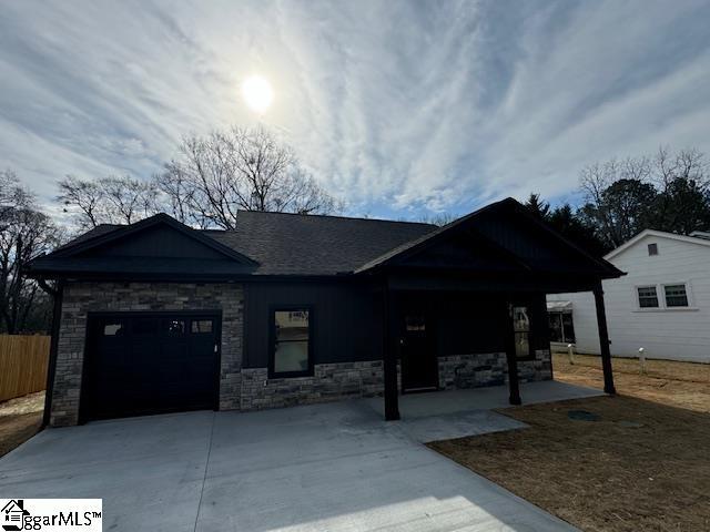 view of front of property featuring a garage, driveway, and fence