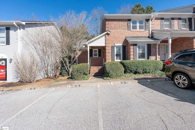 view of front of property with uncovered parking and brick siding